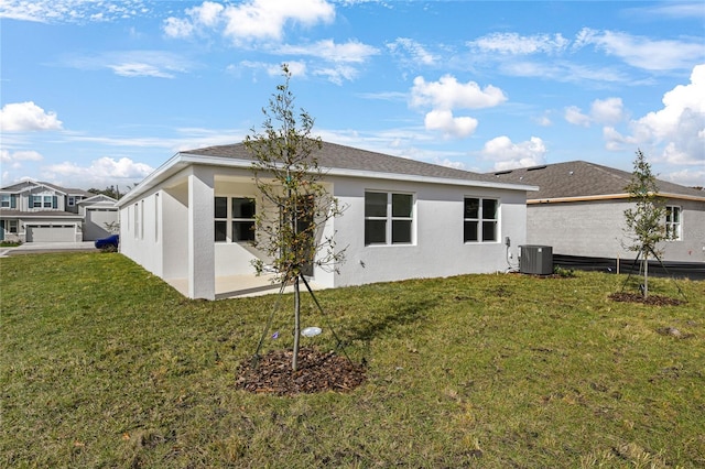 back of house featuring a lawn and central air condition unit