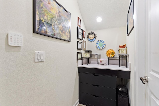 bathroom with baseboards, lofted ceiling, a textured ceiling, and vanity