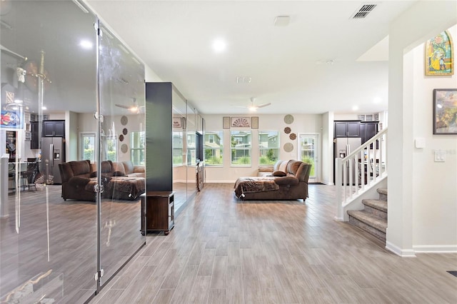 living room featuring ceiling fan and light hardwood / wood-style flooring