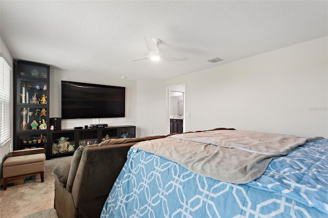 carpeted bedroom with ceiling fan, ensuite bath, a textured ceiling, and multiple windows