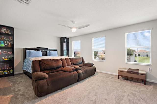 bedroom featuring ceiling fan, multiple windows, and carpet