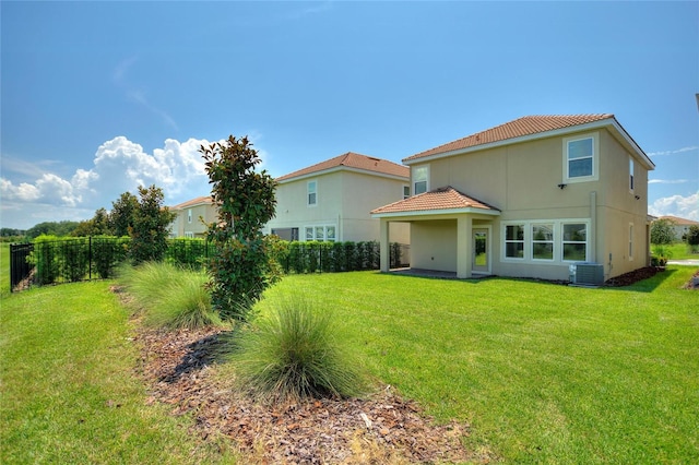 rear view of property with a lawn and central AC unit