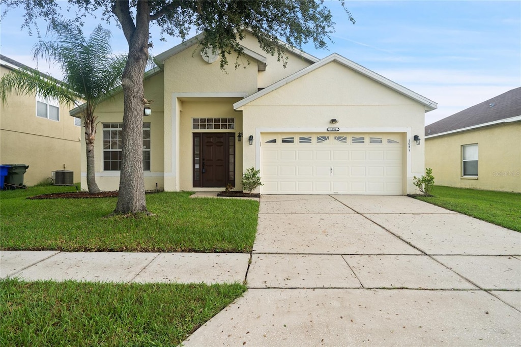 view of front of house featuring a front lawn, cooling unit, and stucco siding