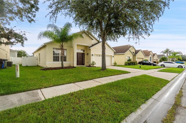 ranch-style house with central AC unit, a front yard, and a garage