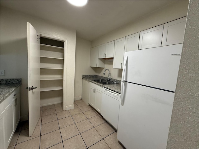 kitchen featuring sink, white appliances, white cabinetry, and light tile patterned floors