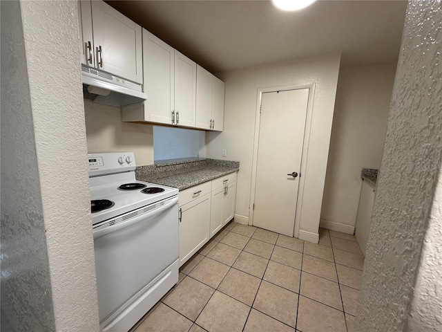 kitchen with white electric range, white cabinets, and light tile patterned flooring