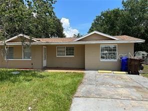 single story home with driveway, stucco siding, and a front yard