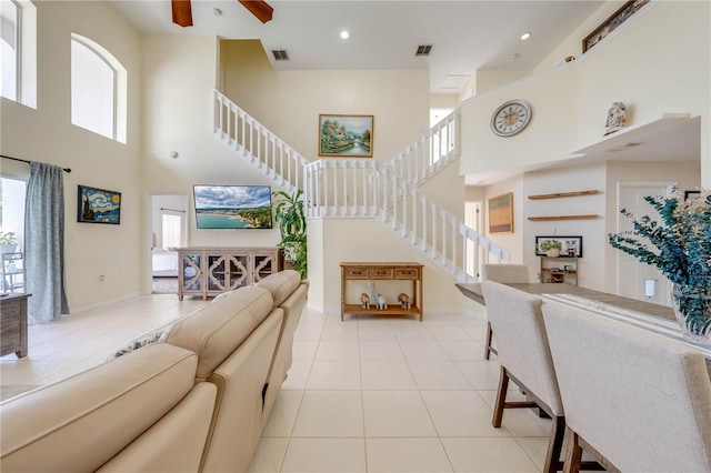 living room with ceiling fan, a high ceiling, and a healthy amount of sunlight