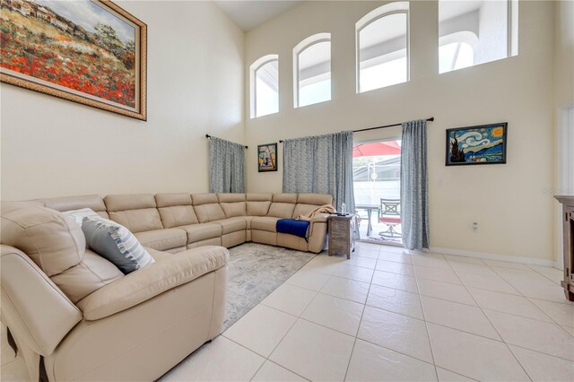 living room with a towering ceiling and light tile patterned floors