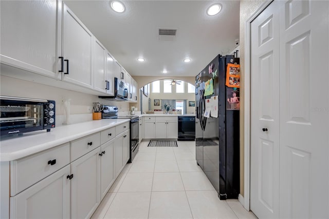 kitchen featuring black appliances, light tile patterned floors, and white cabinets