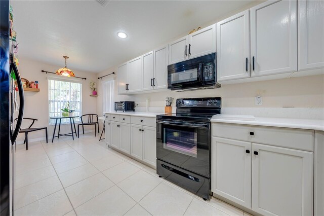 kitchen with hanging light fixtures, black appliances, light tile patterned floors, and white cabinetry