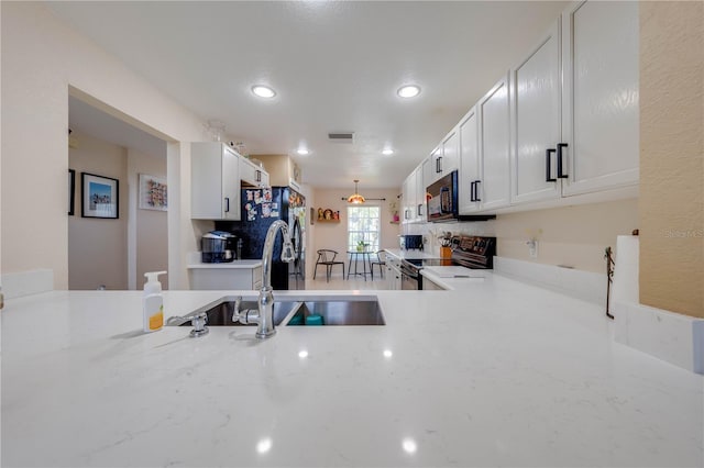 kitchen with tasteful backsplash, white cabinetry, ceiling fan, black appliances, and sink