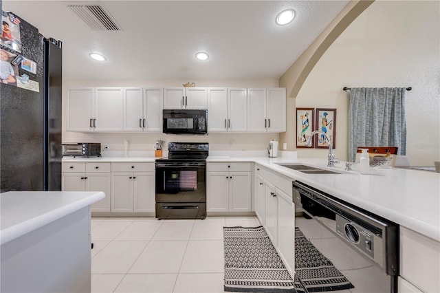 kitchen with light tile patterned floors, sink, black appliances, and white cabinetry