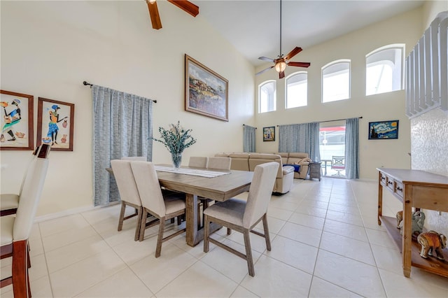 tiled dining room featuring ceiling fan and a high ceiling