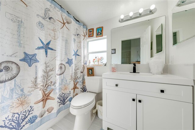 bathroom with toilet, tile patterned floors, and vanity