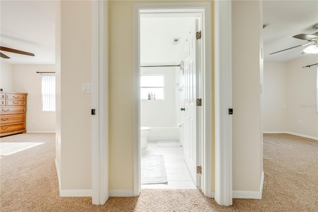 corridor featuring light carpet and a wealth of natural light