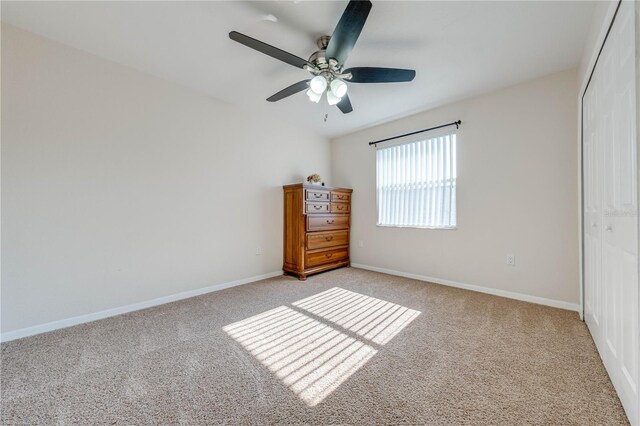 unfurnished bedroom with ceiling fan, light carpet, and a closet