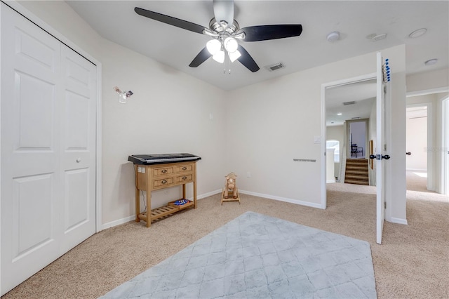 carpeted bedroom featuring ceiling fan and a closet