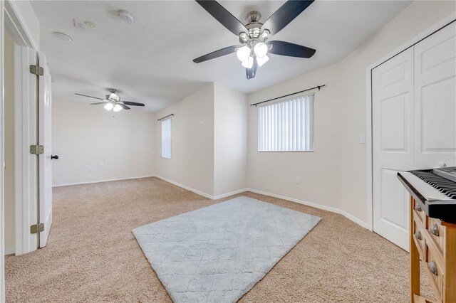 interior space with ceiling fan and light carpet