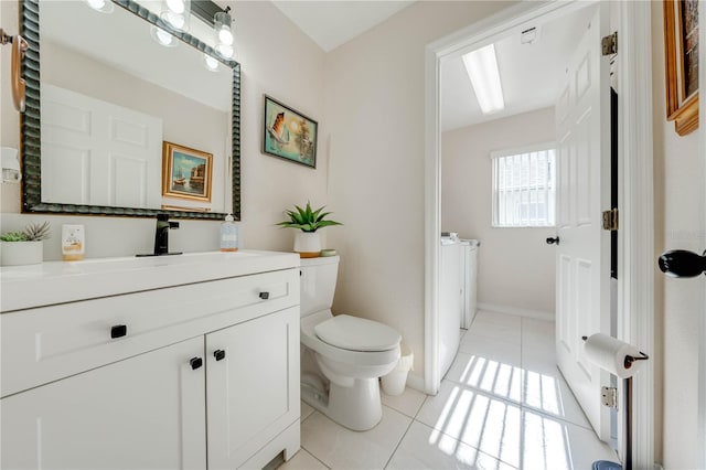 bathroom featuring vanity, independent washer and dryer, tile patterned flooring, and toilet