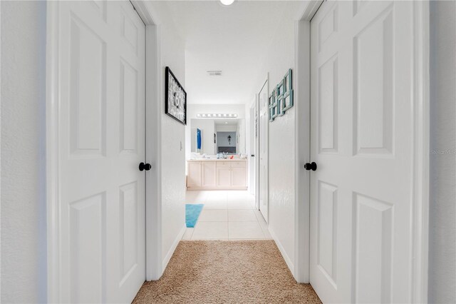 corridor featuring light colored carpet