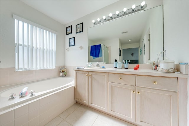 bathroom with tile patterned floors, vanity, and tiled bath