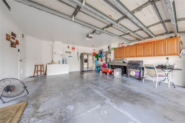 garage with a garage door opener and stainless steel fridge