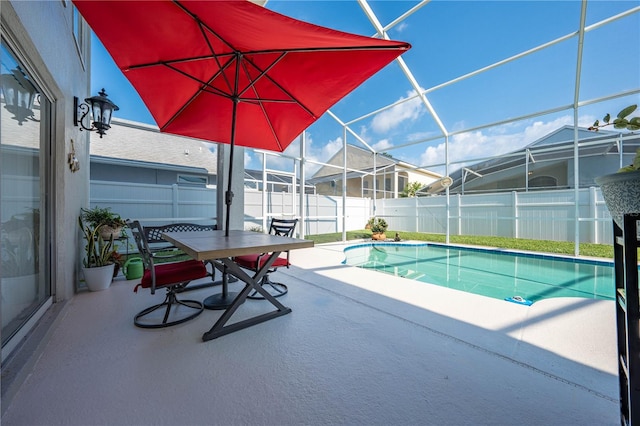 view of pool featuring glass enclosure and a patio area