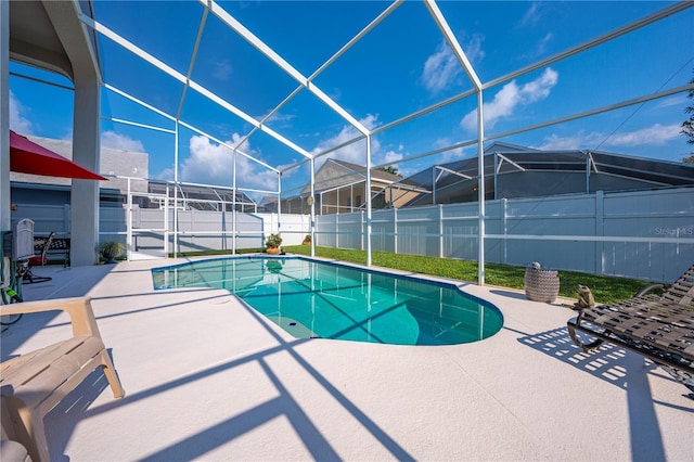 view of pool featuring glass enclosure and a patio area