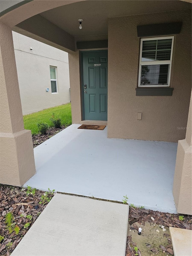 doorway to property featuring stucco siding