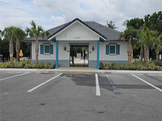 view of building exterior featuring uncovered parking and fence