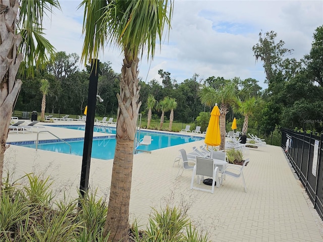 community pool featuring a patio and fence