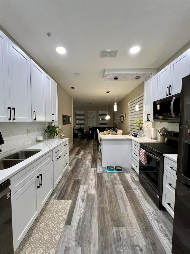 kitchen with stainless steel appliances, tasteful backsplash, hanging light fixtures, white cabinetry, and a peninsula