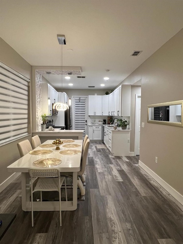 dining area with dark wood-style floors, baseboards, and visible vents