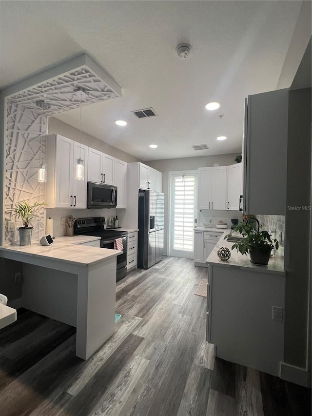 kitchen featuring electric stove, stainless steel microwave, black refrigerator with ice dispenser, light countertops, and white cabinetry