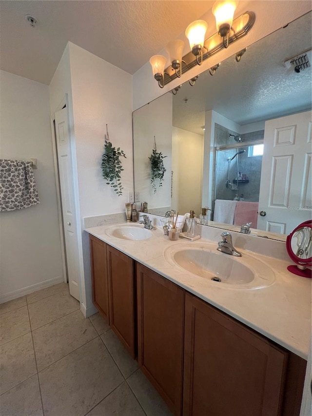 full bath with tile patterned flooring, a sink, a textured ceiling, and double vanity