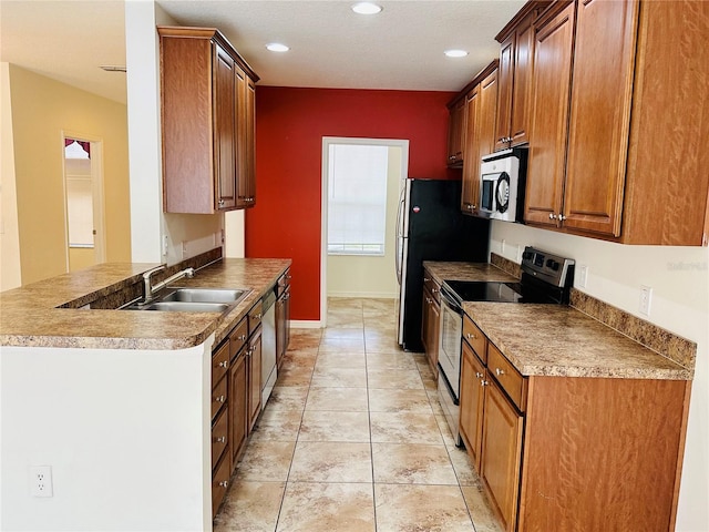 kitchen featuring light tile patterned flooring, stainless steel appliances, kitchen peninsula, and sink