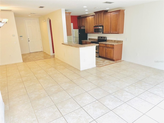 kitchen featuring light tile patterned flooring, stainless steel appliances, and kitchen peninsula