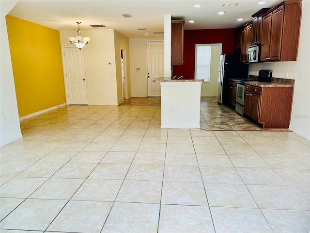 kitchen featuring light tile patterned floors, stainless steel appliances, a chandelier, and stone countertops