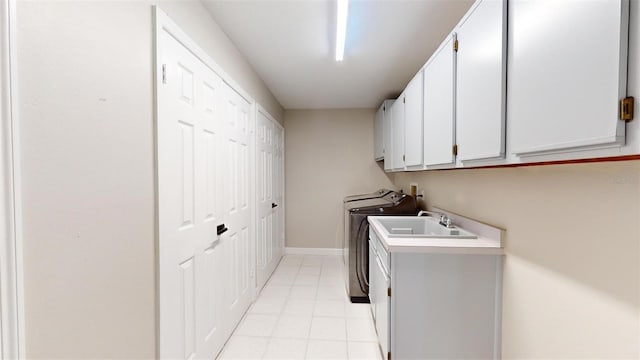 clothes washing area featuring cabinet space, light tile patterned floors, baseboards, independent washer and dryer, and a sink