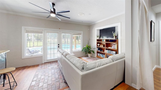 living area with french doors, wood finished floors, a ceiling fan, and crown molding