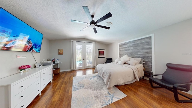 bedroom with ceiling fan, dark hardwood / wood-style flooring, vaulted ceiling, a textured ceiling, and access to outside