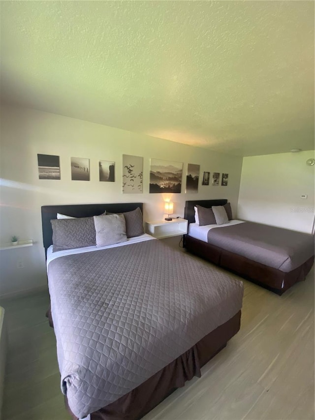 bedroom featuring a textured ceiling and hardwood / wood-style floors