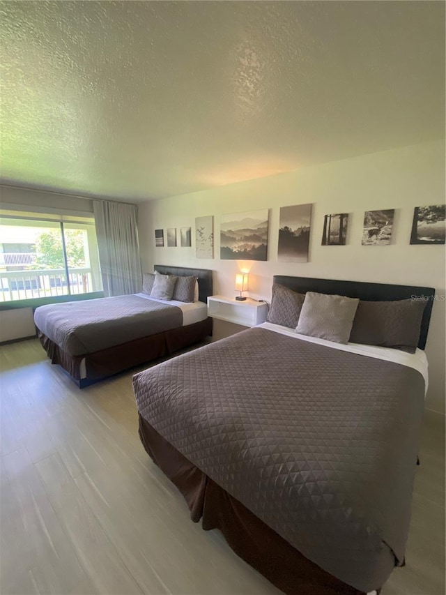 bedroom with a textured ceiling and wood finished floors