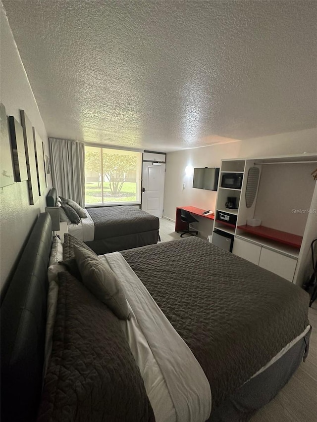 bedroom featuring light carpet and a textured ceiling