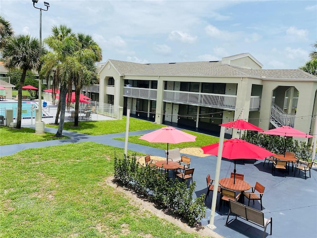 view of community with a lawn, a pool, and a patio area