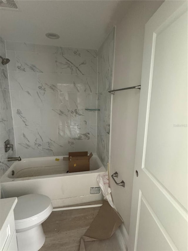 full bathroom featuring wood-type flooring, vanity, toilet, and tiled shower / bath