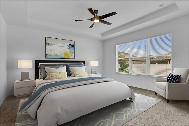 bedroom featuring a tray ceiling, ceiling fan, and carpet flooring