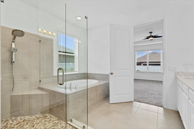 bathroom with tile patterned floors, a healthy amount of sunlight, independent shower and bath, and vanity