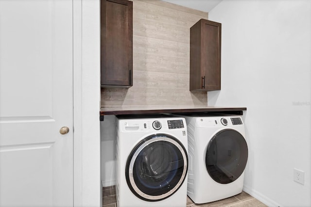 washroom featuring cabinets and washing machine and dryer